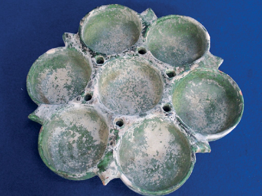 Appraisal: AN ISLAMIC GREEN-GLAZED DISH in the form of a flowerhead