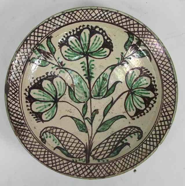 Appraisal: A pottery bowl painted in the Isnik style with flowers