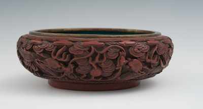 Appraisal: A Carved Cinnabar and Enamel Bowl Deeply carved bowl with