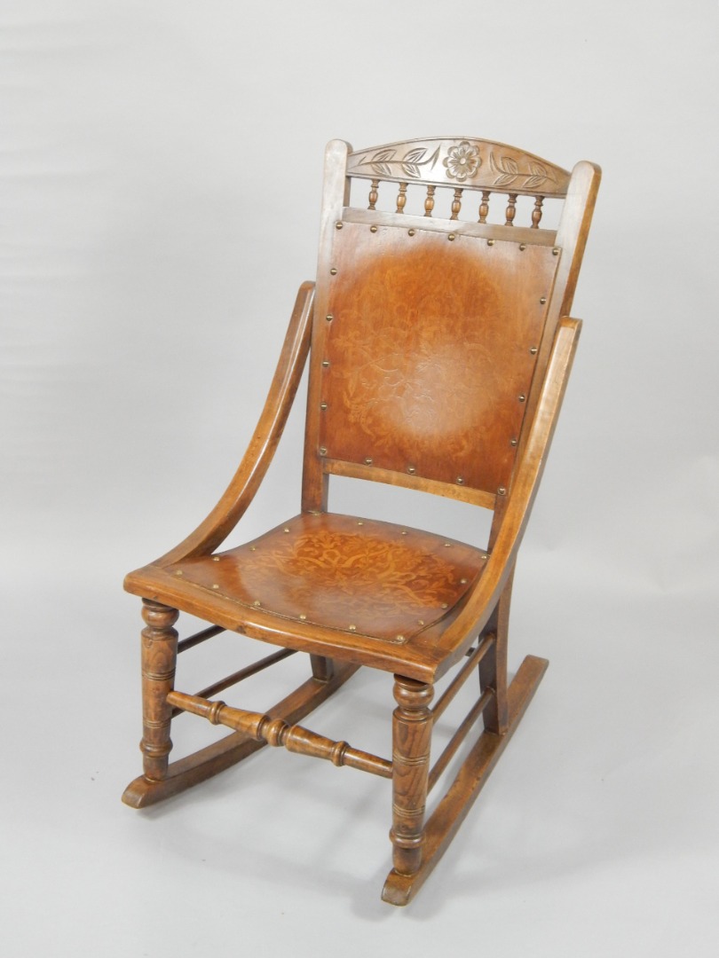 Appraisal: An Arts Crafts oak rocking chair with a floral carved