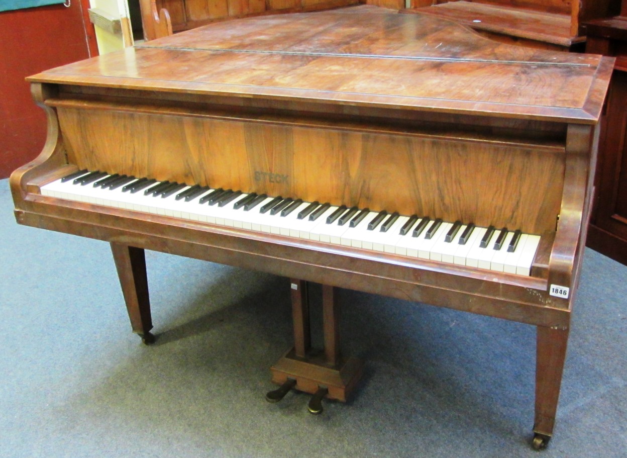 Appraisal: A walnut cased iron framed overstrung baby grand piano by