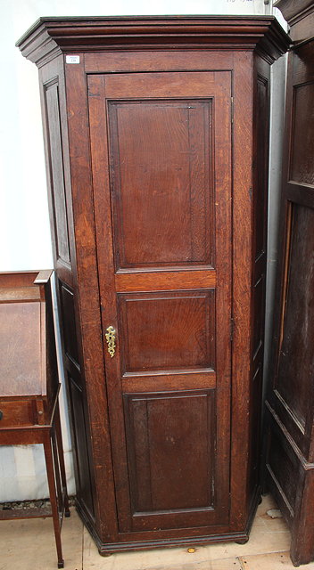 Appraisal: A PANELLED OAK HALL CUPBOARD with canted sides and single