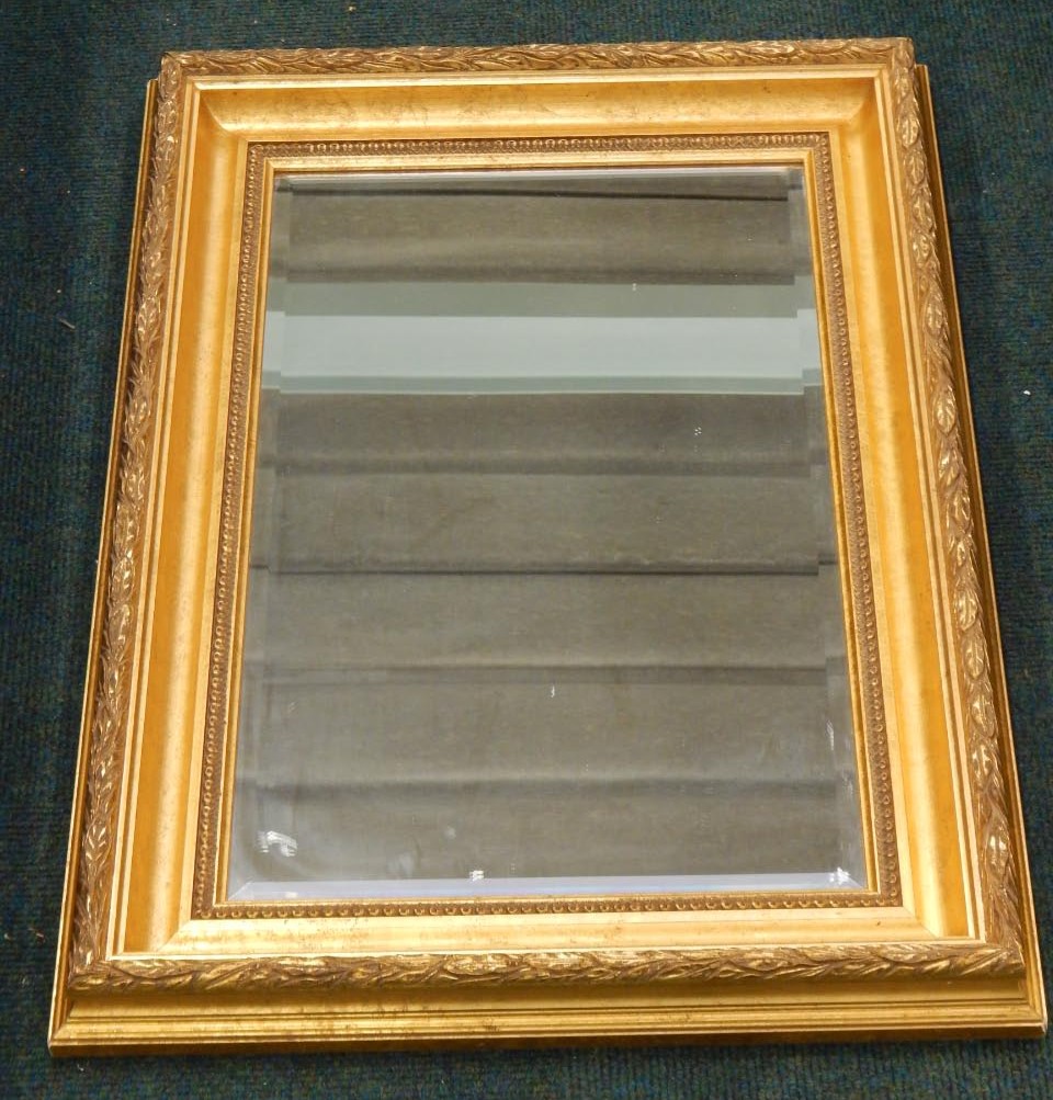 Appraisal: A modern gilt gesso rectangular wall mirror with a moulded