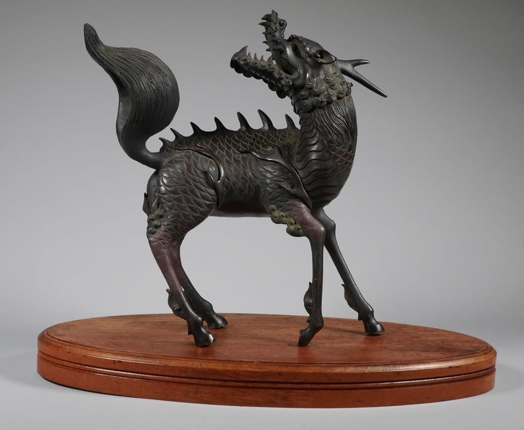 Appraisal: Cast metal Qilin winged dragon incense burner on a wooden