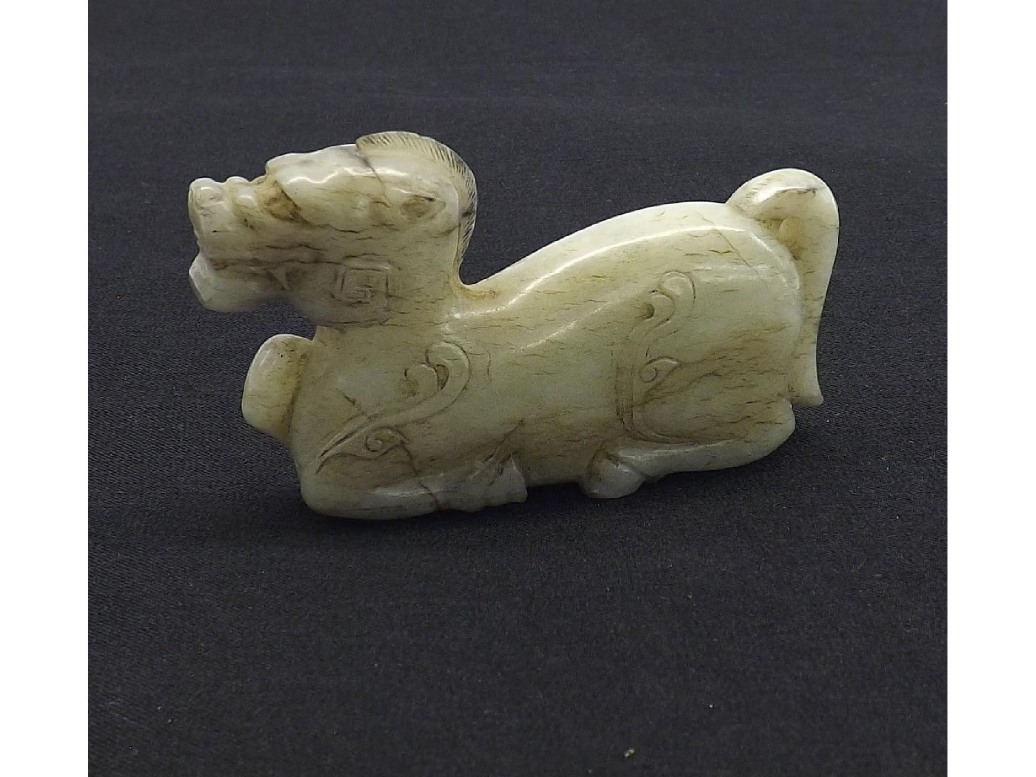 Appraisal: Pale celadon carved jade with dark and light brown streaks