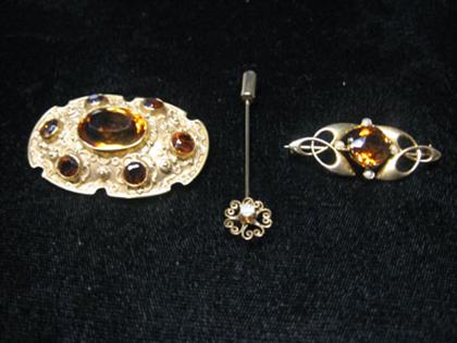 Appraisal: Three pins gem set brooches Shield-shaped pin with large amber-colored