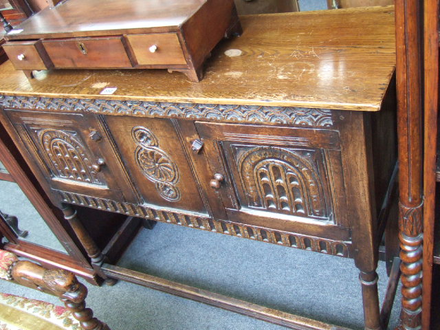 Appraisal: A carved oak small side cabinet with two cupboards on