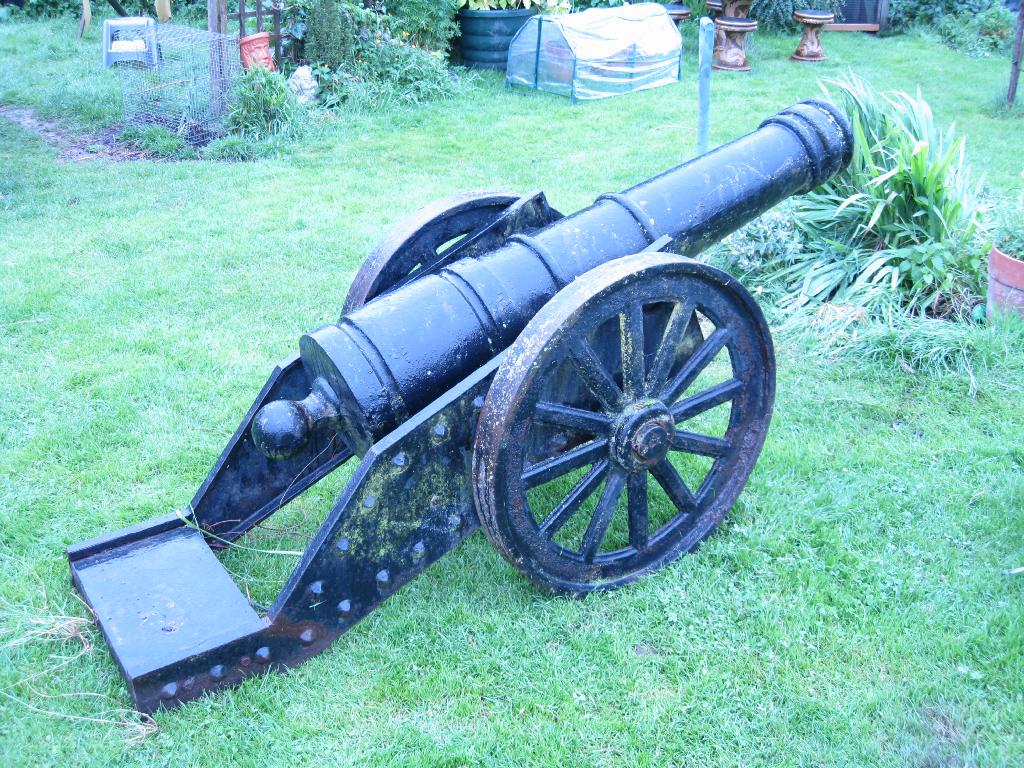 Appraisal: A large painted iron Canon on pair of spoked wheels