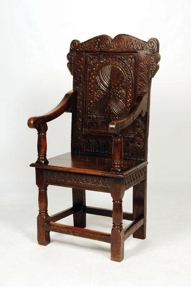 Appraisal: A JAMES I OAK WAINSCOTE ARMCHAIR with a scroll carved