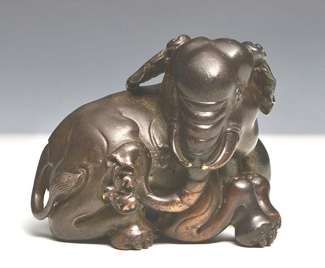 Appraisal: A CHINESE BRONZE MODEL OF AN ELEPHANT seated with head