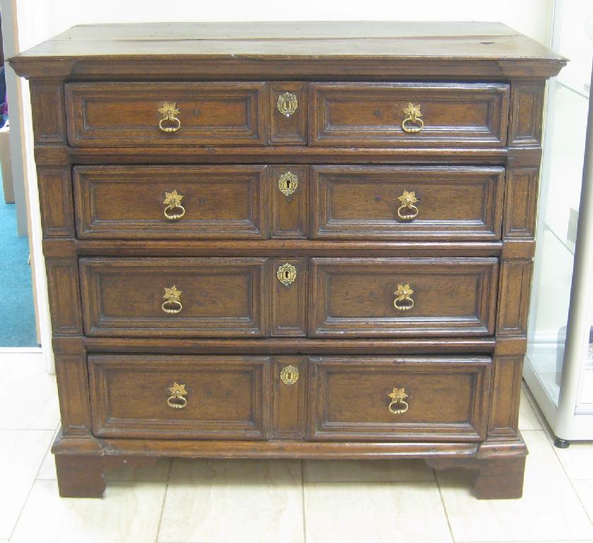 Appraisal: An antique oak Chest of four graduated panelled drawers on