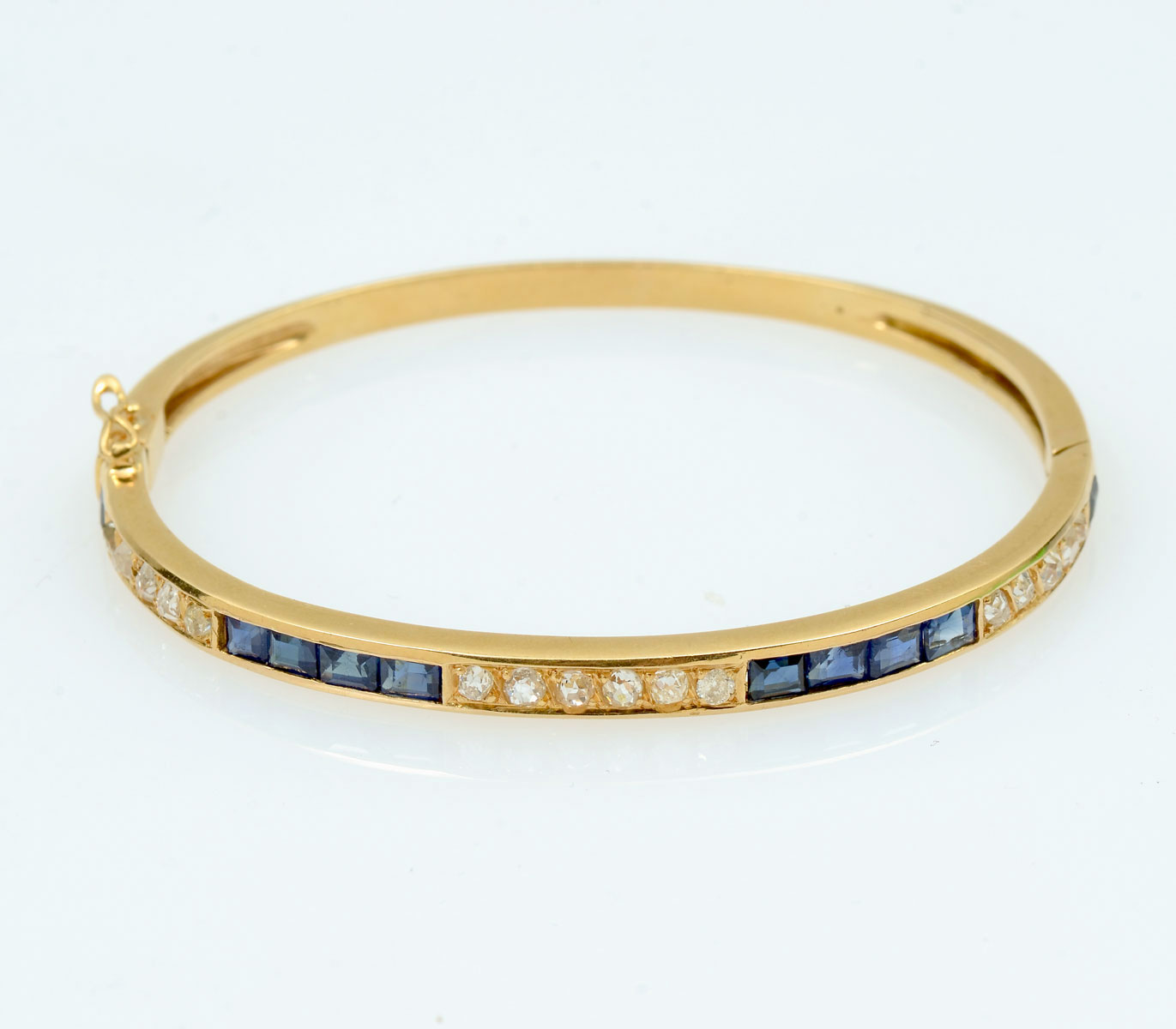 Appraisal: K DIAMOND SAPPHIRE BANGLE K yellow gold bangle bracelet contains