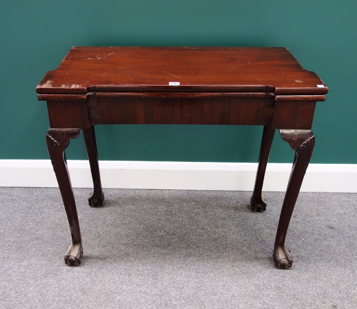 Appraisal: An th century mahogany card table with concave top on