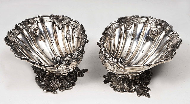 Appraisal: A PAIR OF EDWARDIAN SILVER SCALLOP SHAPED PEDESTAL SALTS by