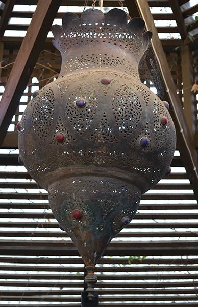 Appraisal: A MOROCCAN LAMPthe lobed body of pierced metal with coloured