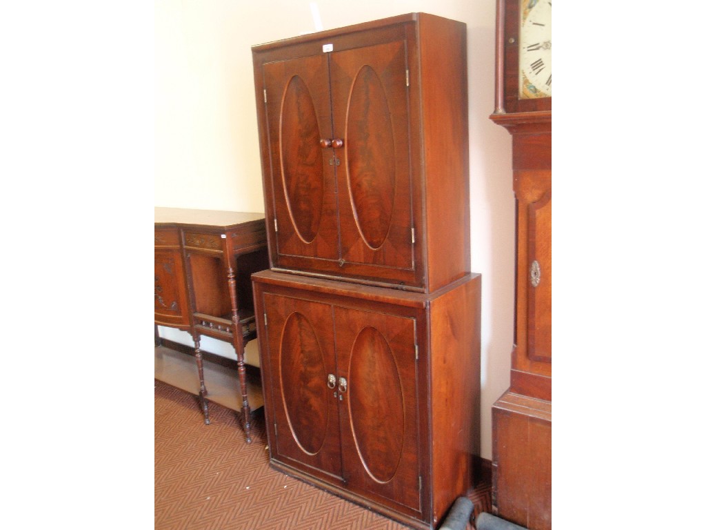 Appraisal: A Georgian mahogany cupboard of two parts each having oval