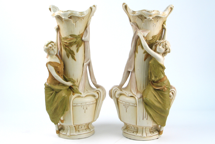 Appraisal: PAIR ROYAL DUX POTTERY FIGURAL VASES On each a young