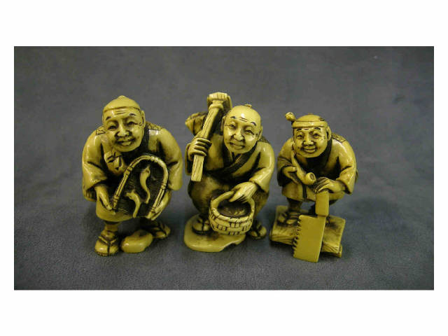 Appraisal: Three stained ivory netsuke depicting man carrying a basket and