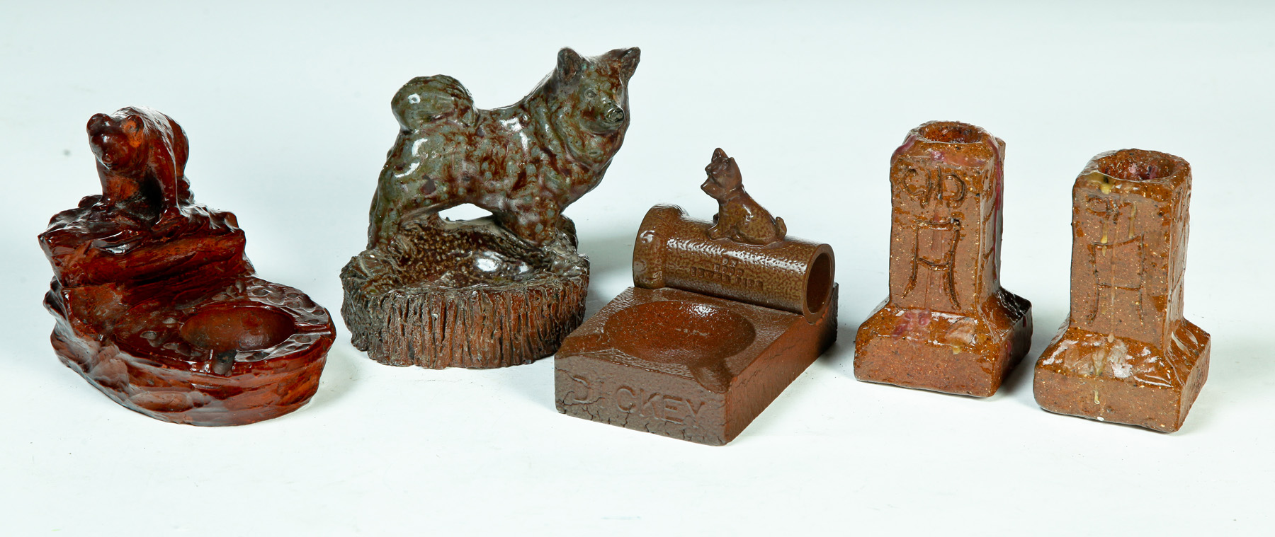 Appraisal: THREE AMERICAN SEWERTILE ASHTRAYS AND A PAIR OF CANDLESTICKS First