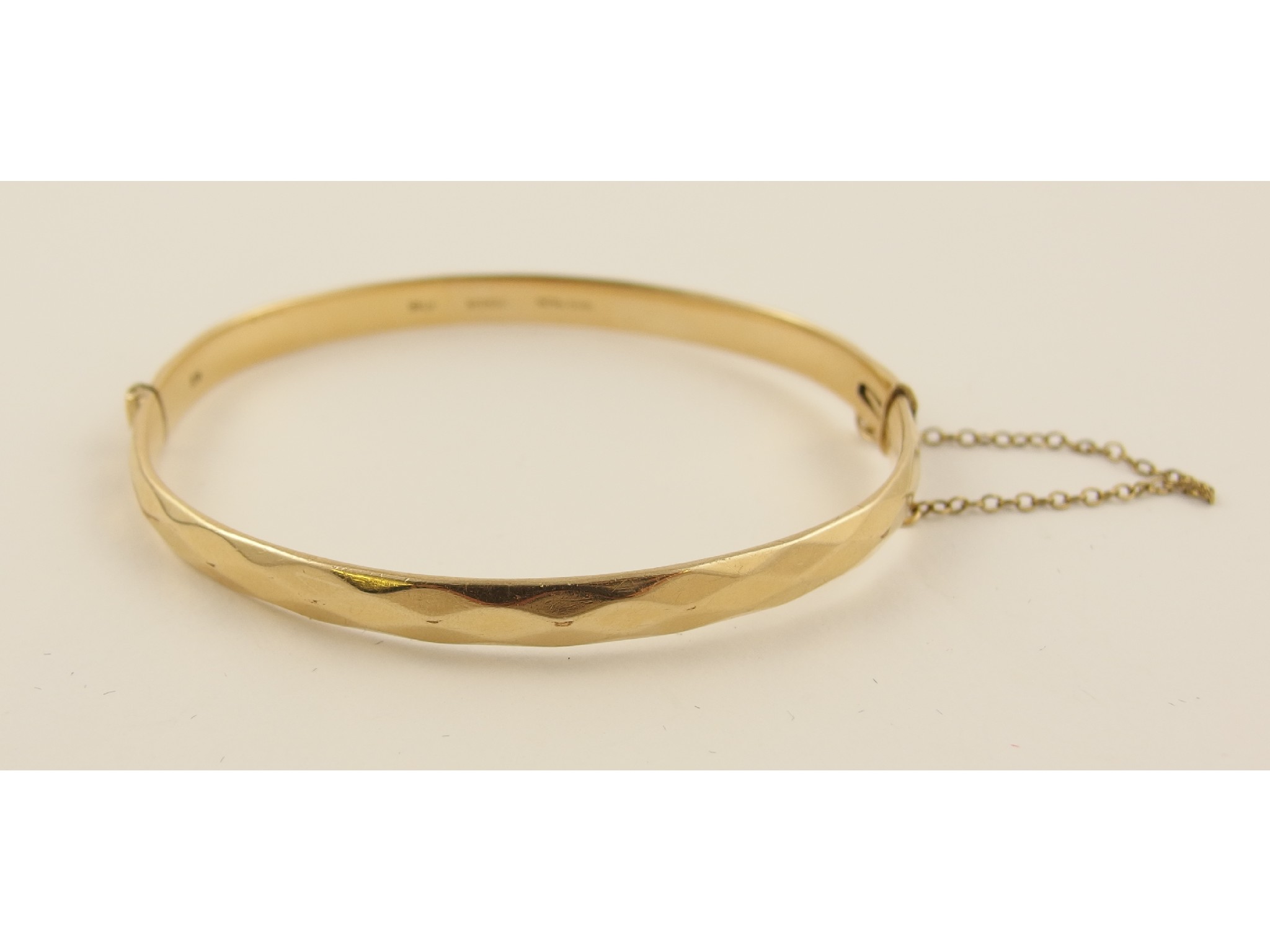 Appraisal: A ct metal core bangle with facet detail