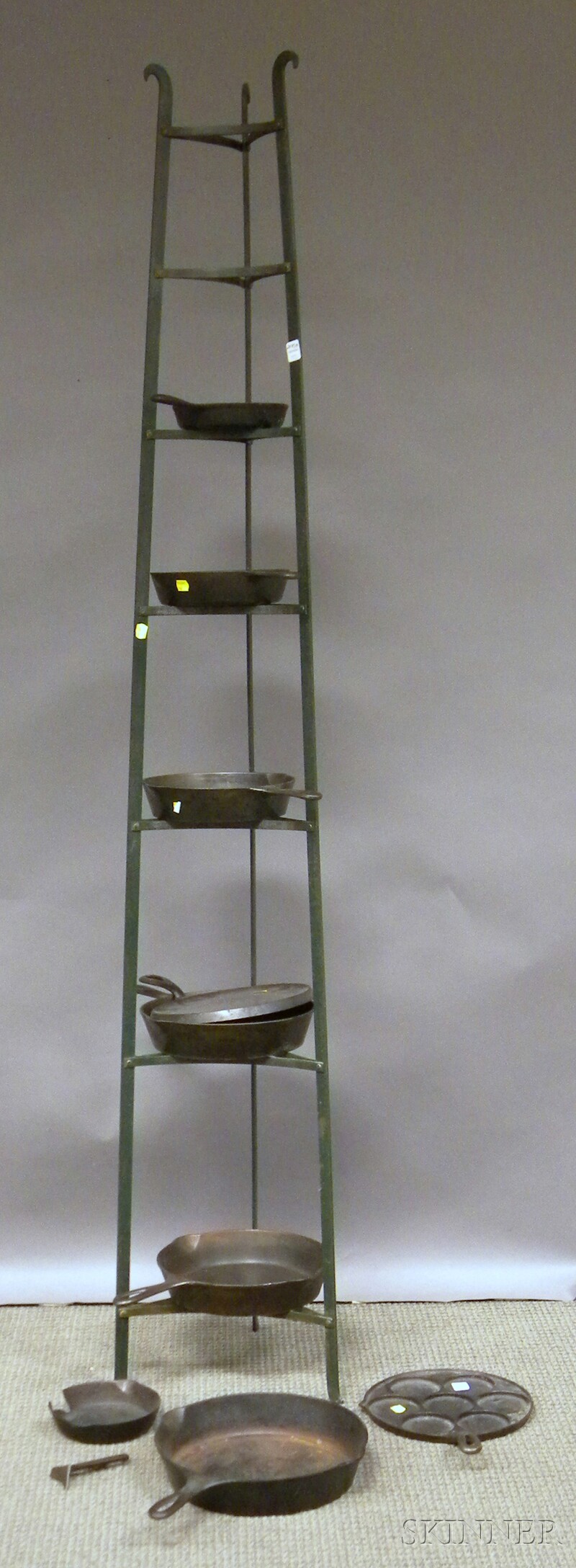 Appraisal: Green-painted Iron Seven-tier Pot Rack with Nine Cast Iron Pans