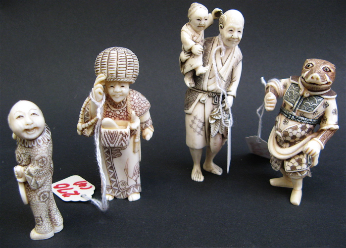 Appraisal: FOUR IVORY CARVED FIGURES tall man holding child and egg