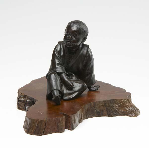 Appraisal: JAPANESE BRONZE FIGURE Young boy in sitting position on wooden