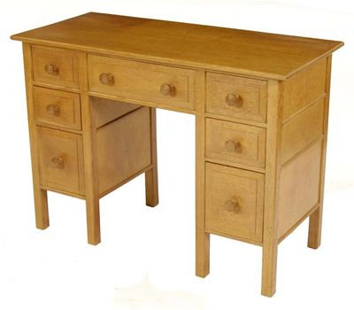 Appraisal: A Cotswold School oak desk the design attributed to Peter