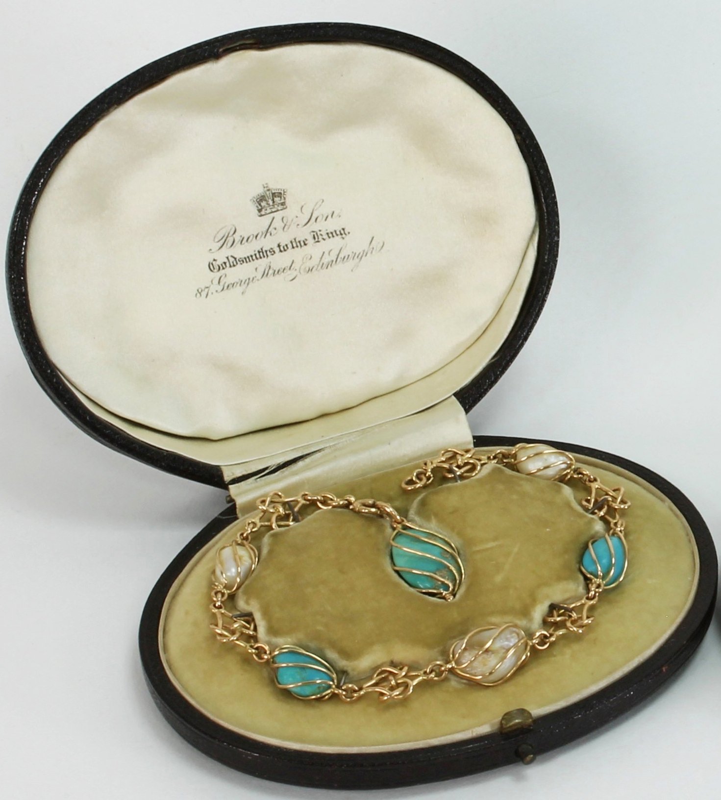 Appraisal: A baroque pearl and turquoise bracelet the cage set pearl