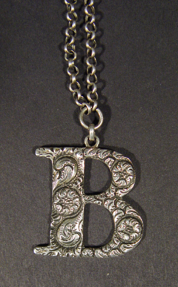 Appraisal: Irish silver decanter label letter 'B' embossed with flowers on