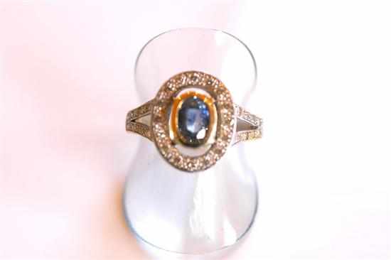 Appraisal: AN OVAL SAPPHIRE AND DIAMOND CLUSTER RING IN CT WHITE