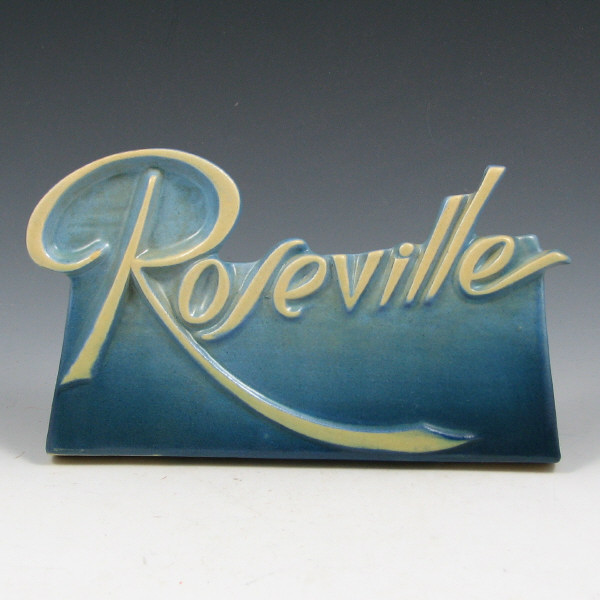 Appraisal: Roseville dealer sign in blue with cream-colored script logo Mint