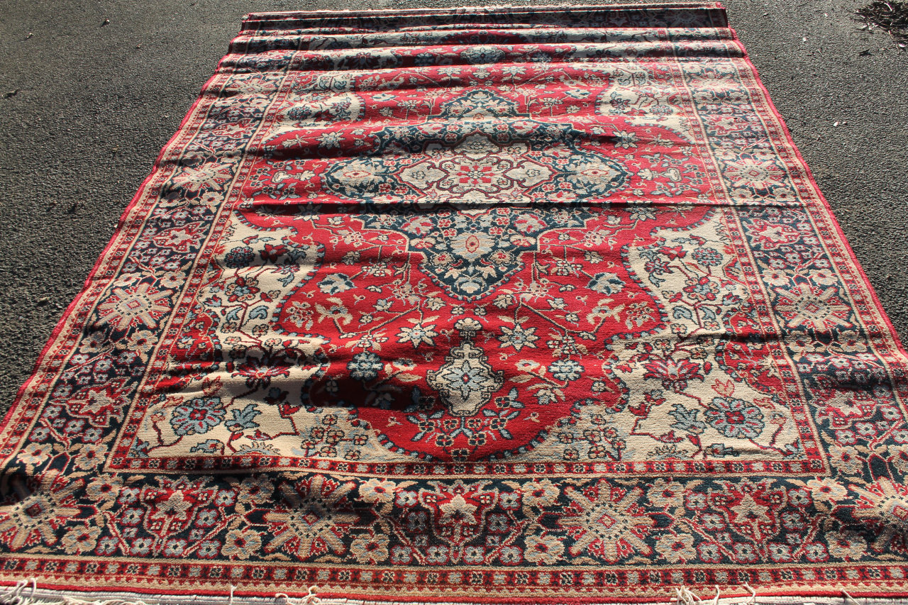 Appraisal: A thC machine woven rug in floral geometric pattern predominantly