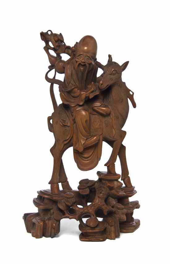 Appraisal: A Chinese Wood Carving of Shoulao Riding a Spotted Deer