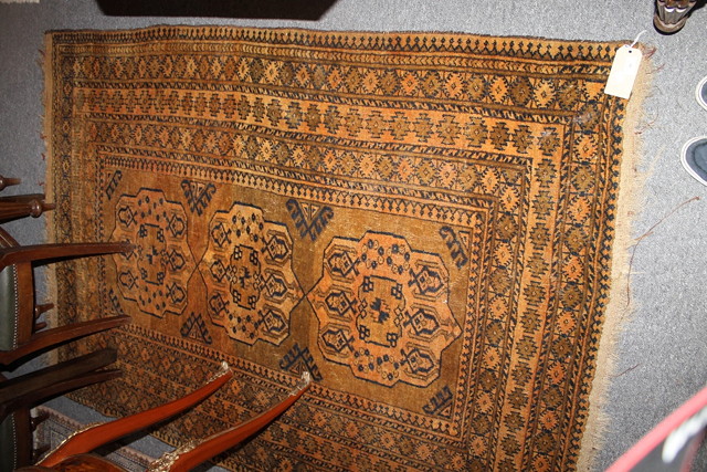 Appraisal: AN AFGHAN HONEY GROUND RUG with three central medallions and