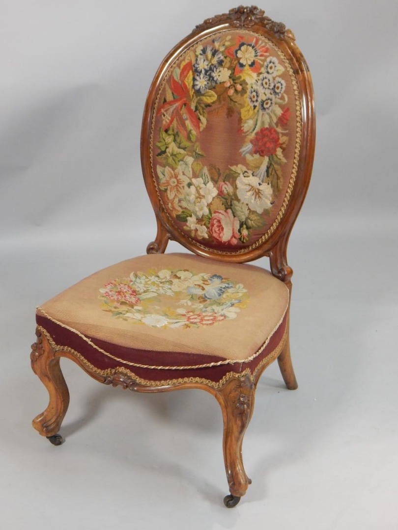 Appraisal: A Victorian walnut nursing chair the oval back carved with