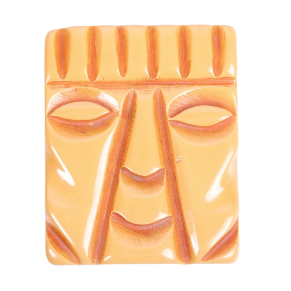 Appraisal: CARVED BUTTERSCOTCH BAKELITE RECTANGULAR TIKI GOD FACE PIN H X