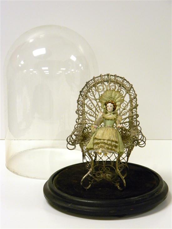 Appraisal: Dome-encased doll in elaborate metalwork chair polychrome porcelain doll with