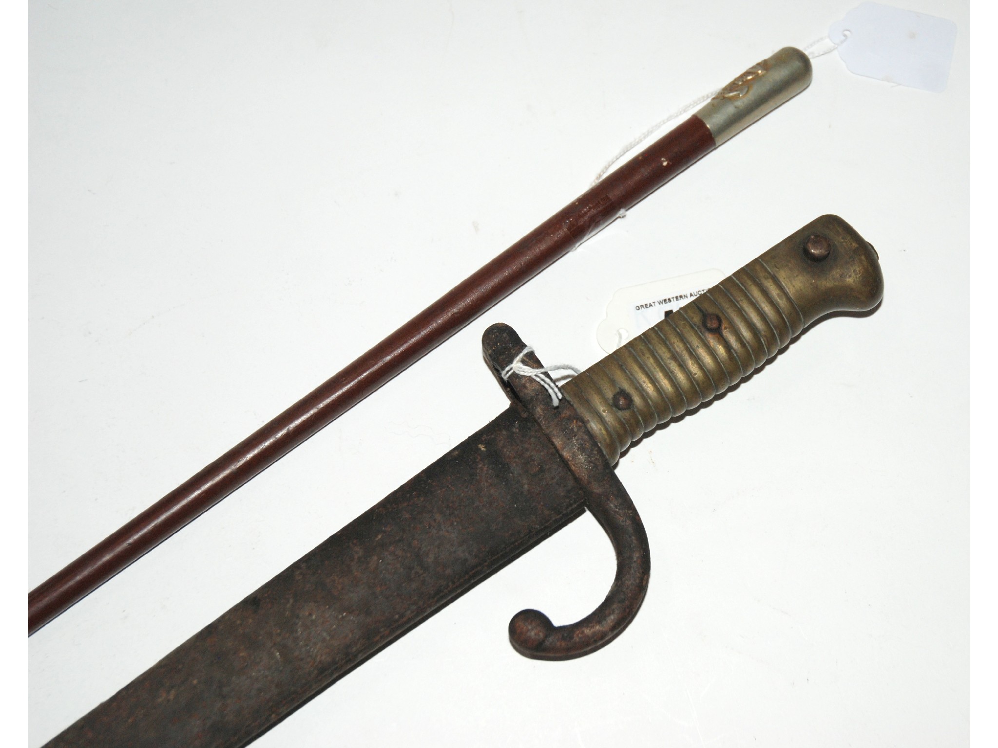 Appraisal: A bayonet in metal scabbard and a swagger stick