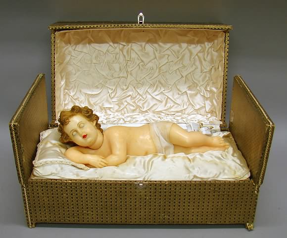 Appraisal: Mechanical wax baby in decorated wood box Poured wax baby