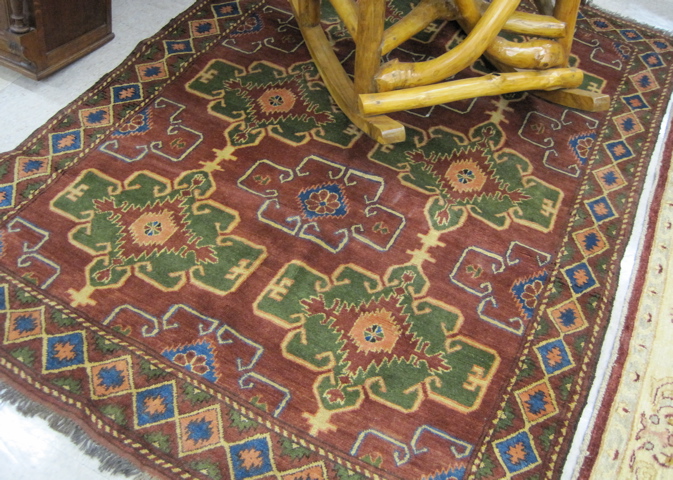 Appraisal: AFGHANI CAUCASIAN AREA RUG featuring six green geometric medallions on