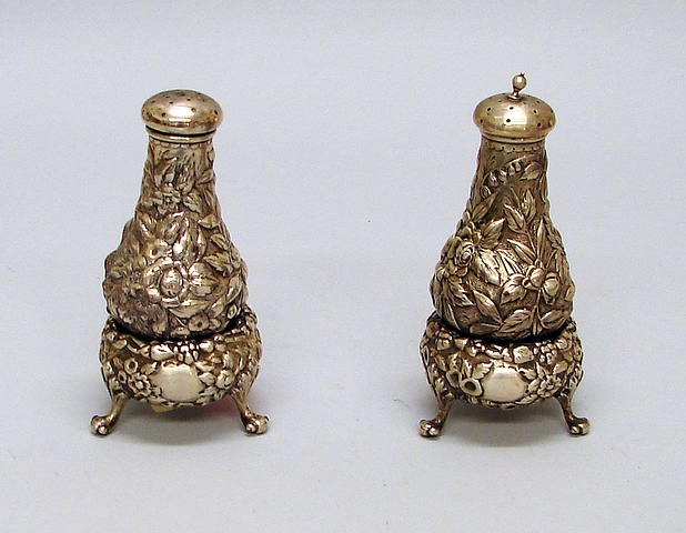 Appraisal: Repousse floral decoration salts with feet pair of pepper shakers