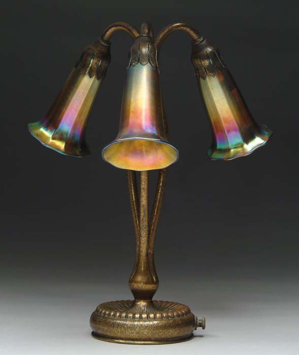 Appraisal: TIFFANY STUDIOS THREE-LIGHT LILY LAMP This lamp begins with a