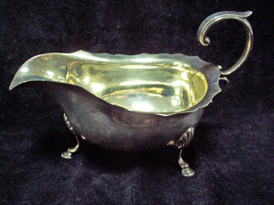 Appraisal: A sauceboat of th Century design with open scroll handle