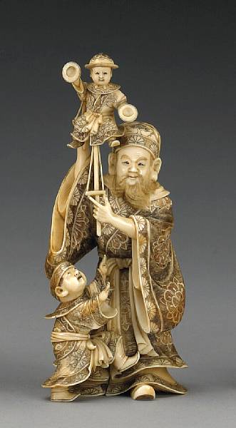 Appraisal: An ivory okimono of a puppeteer and boy Meiji Period