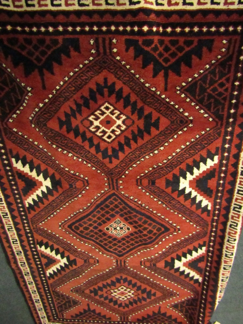 Appraisal: A Caucasian style wool rug machine woven with geometric motifs