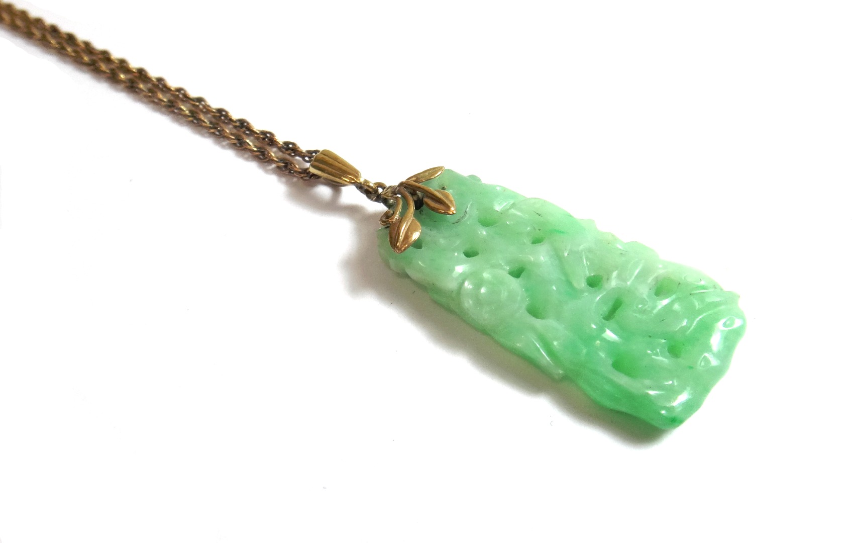 Appraisal: A carved jade drop shaped pendant with a foliate suspension