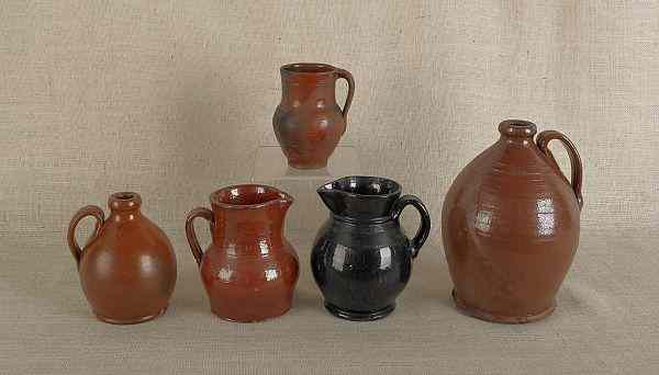 Appraisal: Two redware jugs th c together with three pitchers tallest