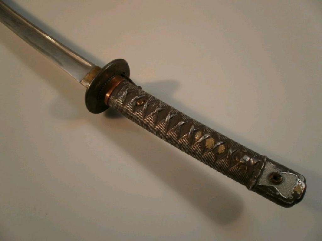 Appraisal: A thC Japanese Katana the metal grip fashioned in the