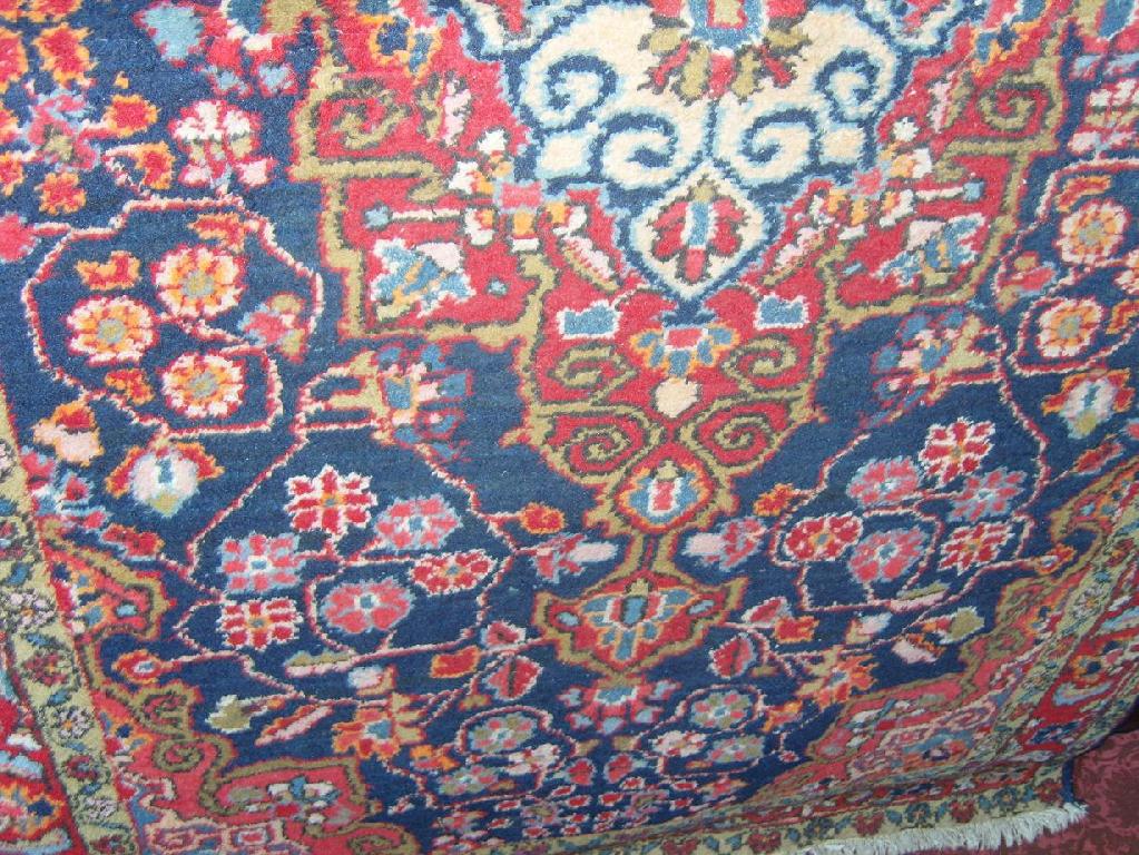 Appraisal: A blue ground knit wool rug with polychrome stylised floral